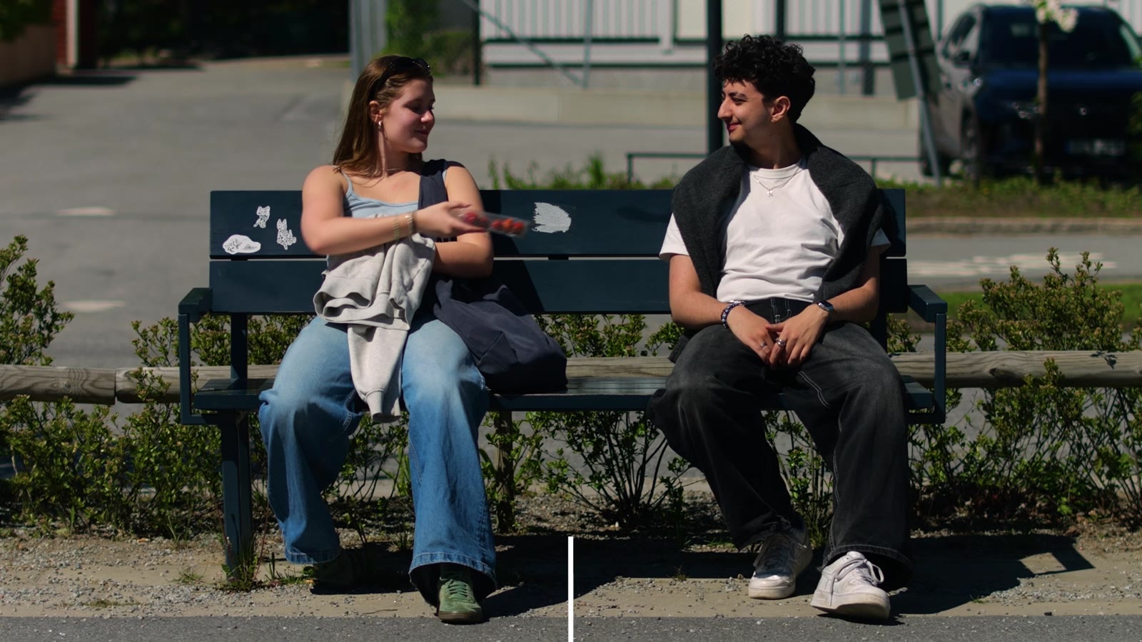 The two travellers meet on a bench as the split screen dissolves